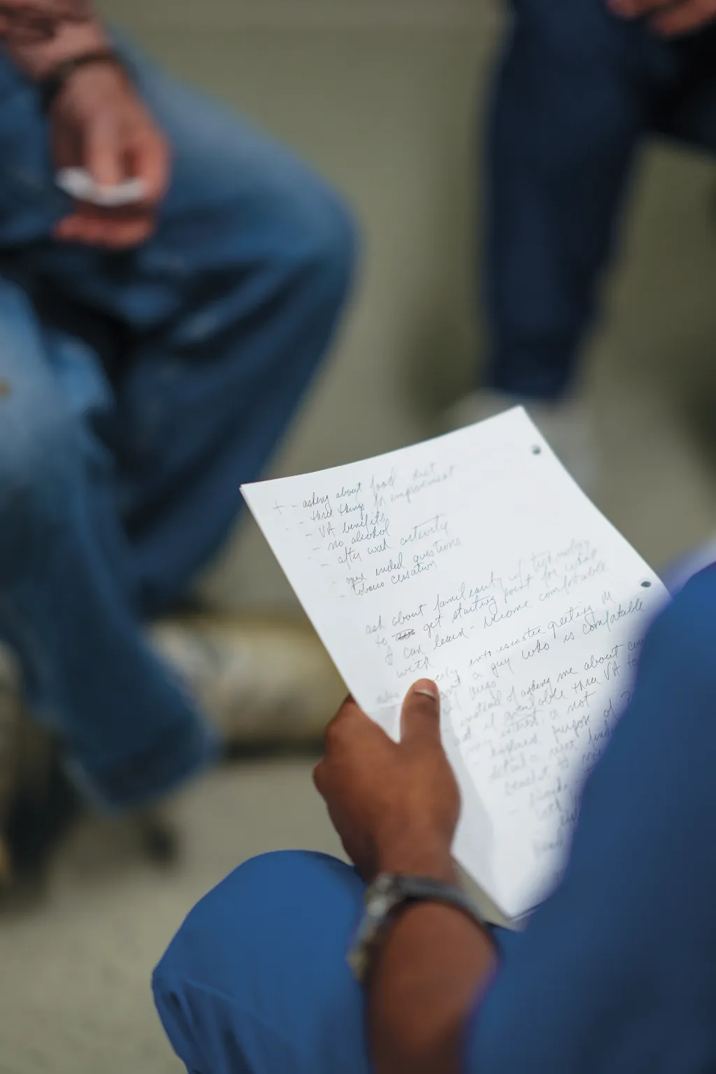 Varun Kota, a College of Osteopathic Medicine student, reviews handwritten notes during an interprofessional case study session with Michael, a patient actor.