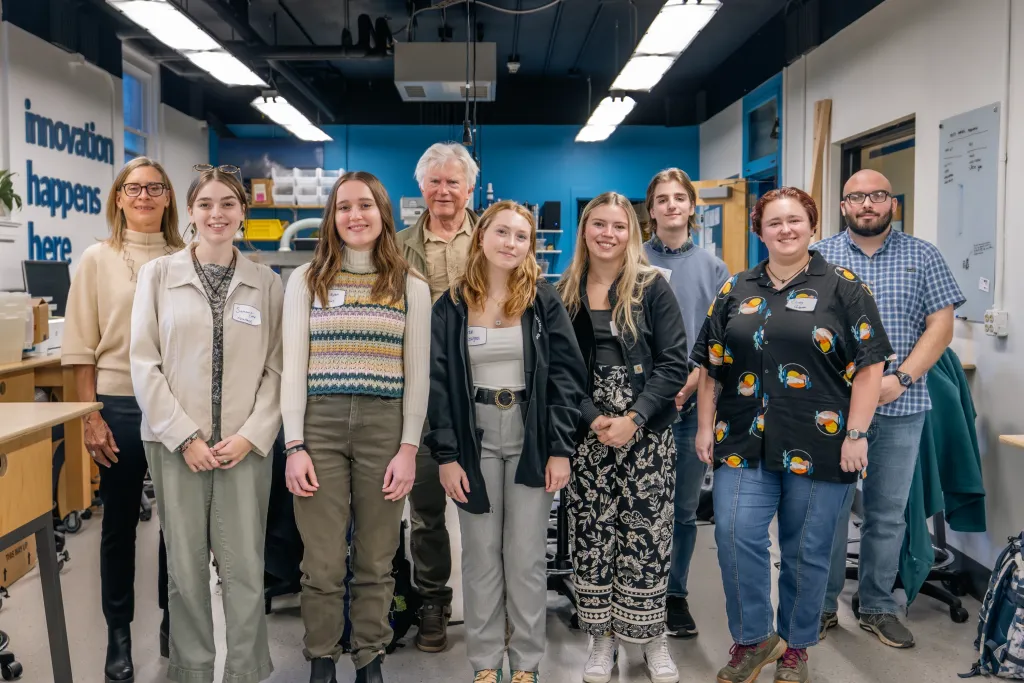 David Shaw poses with a group of Shaw Innovation Fellows in the UNE Center for Innovation and Entrepreneurship P.D. Merril Makerspace, standing among workbenches and equipment