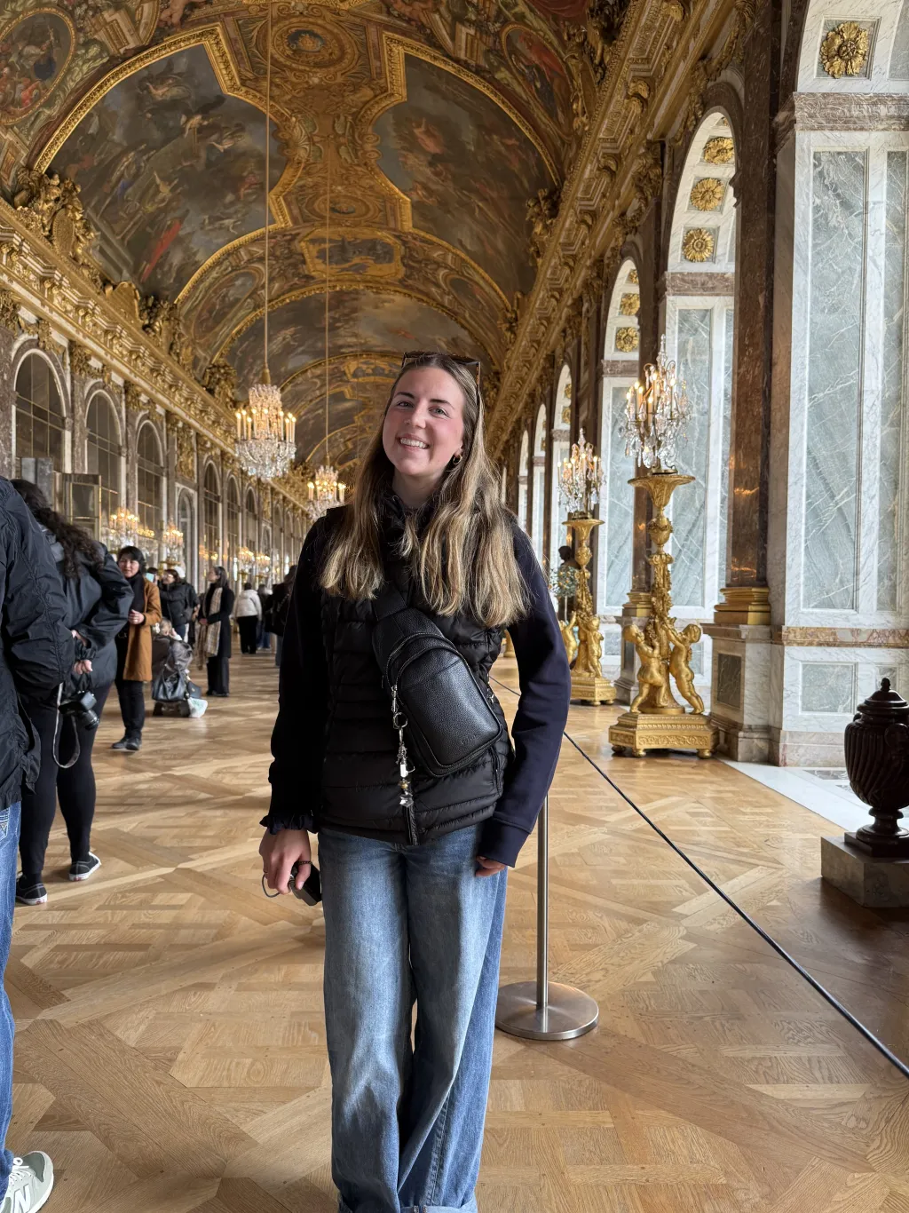 Cally Gudroe poses in the Hall of Mirrors in the Palace of Versailles