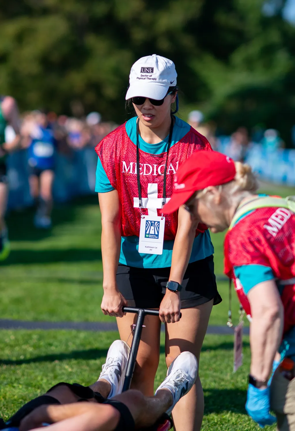 A race volunteer assists an injured runner
