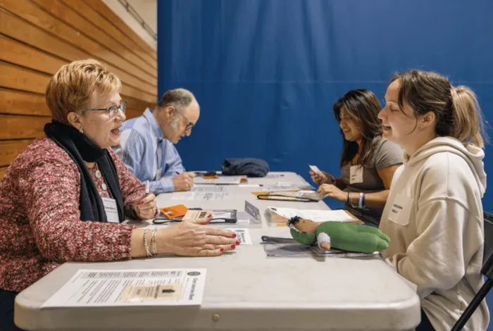 Students and community members talk together at a table during a U N E Center for Excellence in Aging and Health event.