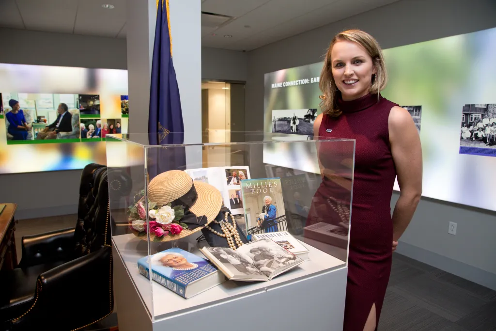 Ellie LeBlond Sosa poses next to items that belonged to her grandmother, Barbara Bush, in UNE's Bush Legacy Collection