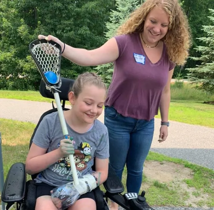 A camper plays lacrosse to improve the function of her left side