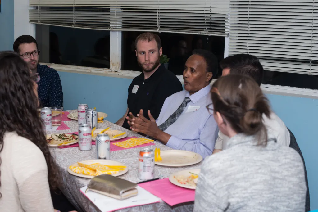 A group of UNE students talk with a community health worker