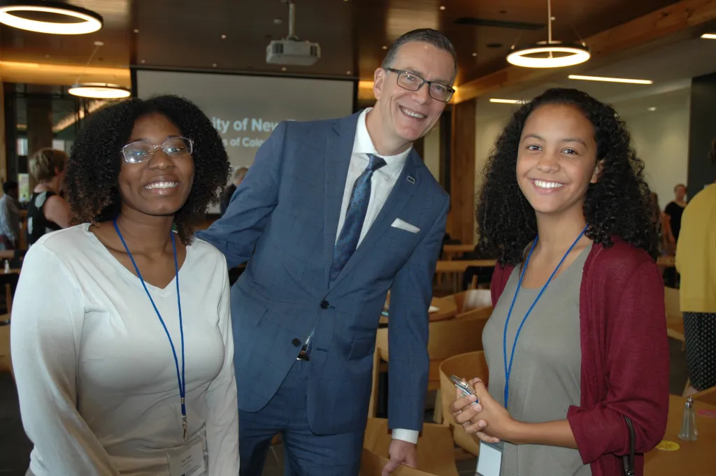President Herbert socializes with two new UNE students before the breakfast begins.