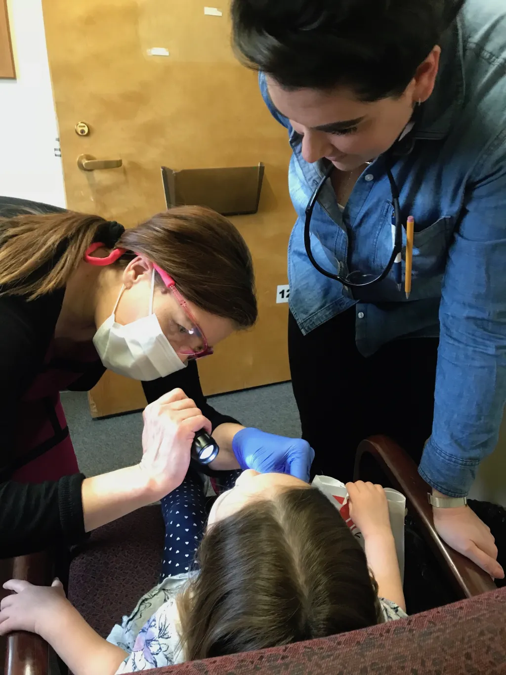 Nicole Kimmes takes a close look inside a young child's mouth for any potential dental problems