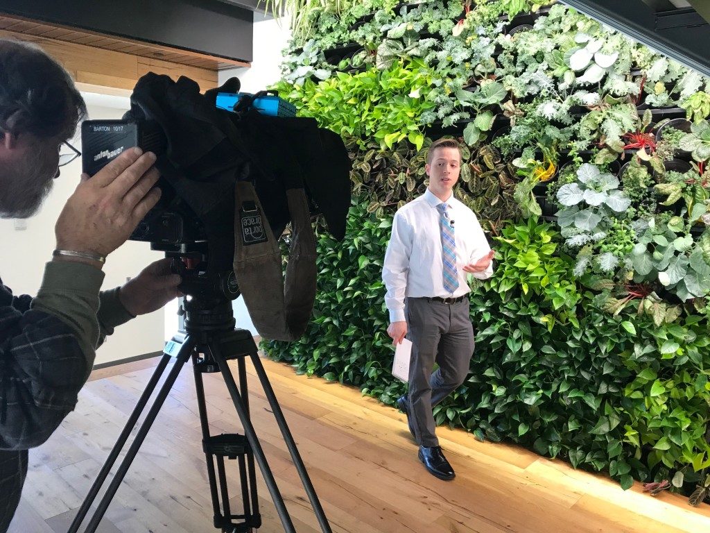 WGME's Dustin Bonk in front of UNE's Living Wall