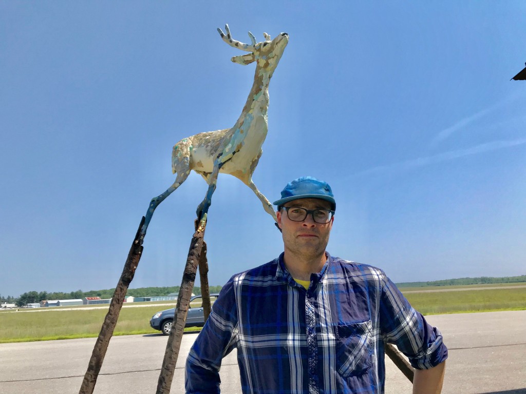 Andy Rosen with one of his sculptures at the airport in Sanford