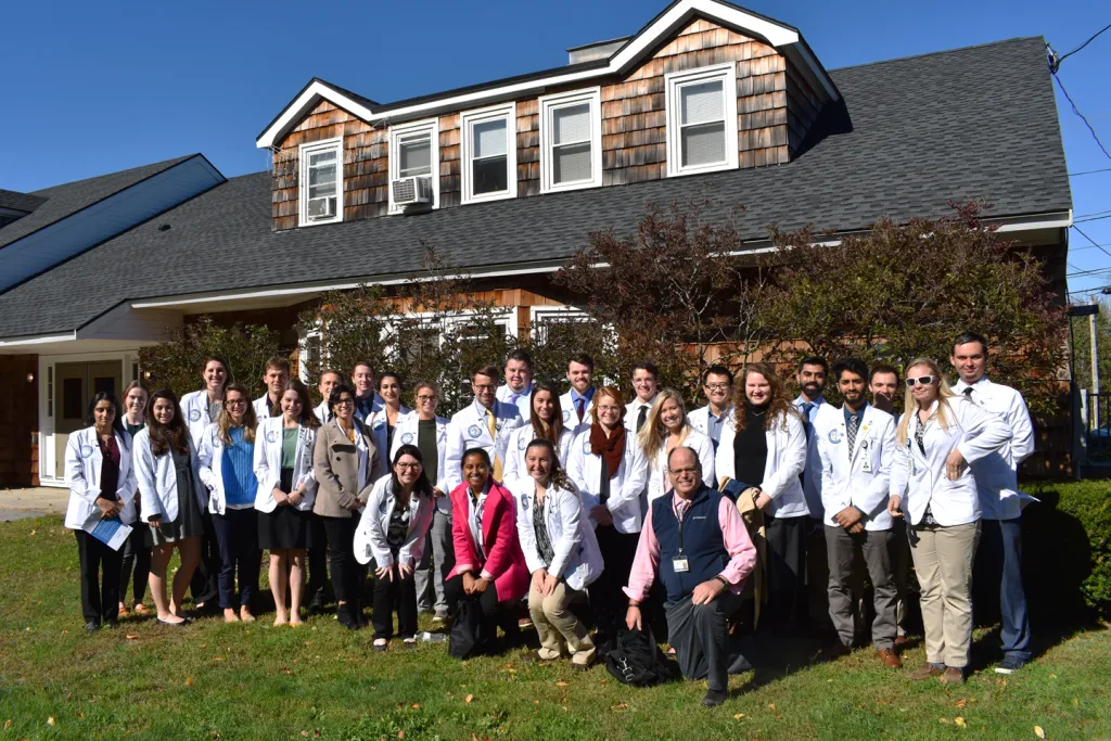 Marc Kaplan, D.O., Sweetser’s medical director (front row, far right), joins the COM students for a group photo. Kaplan, a COM g