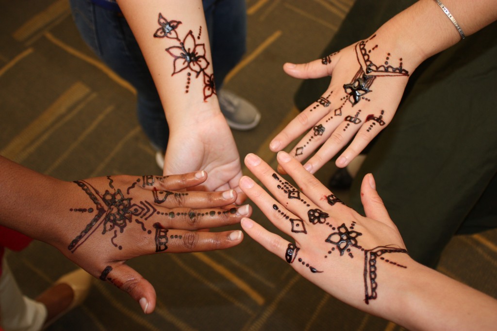 Attendees show off their henna tattoos
