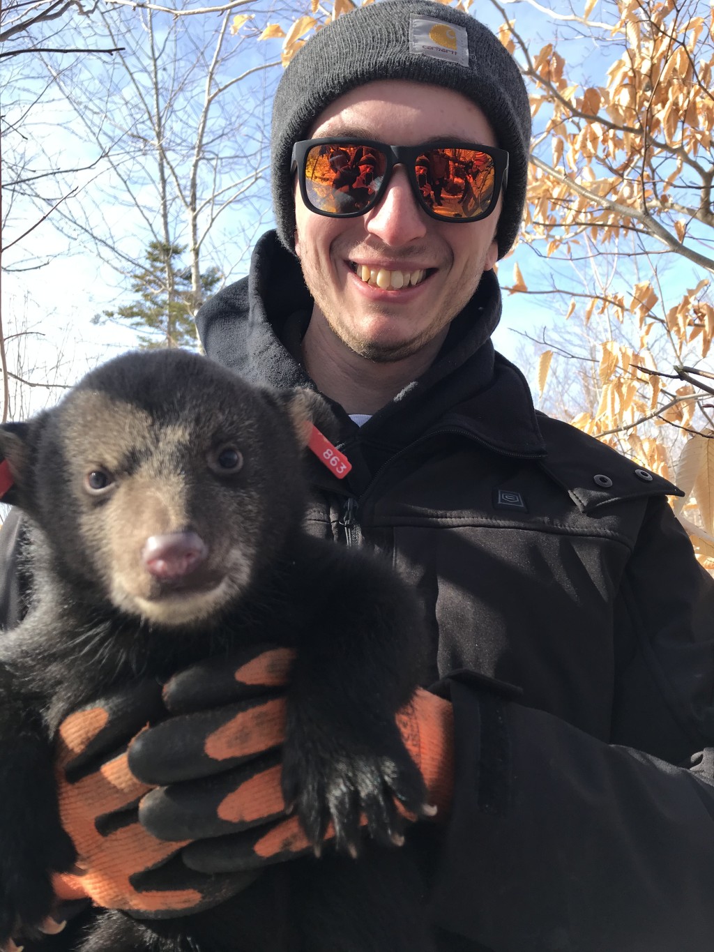 Student Ethan Maskiell holds a six-week old bear cub