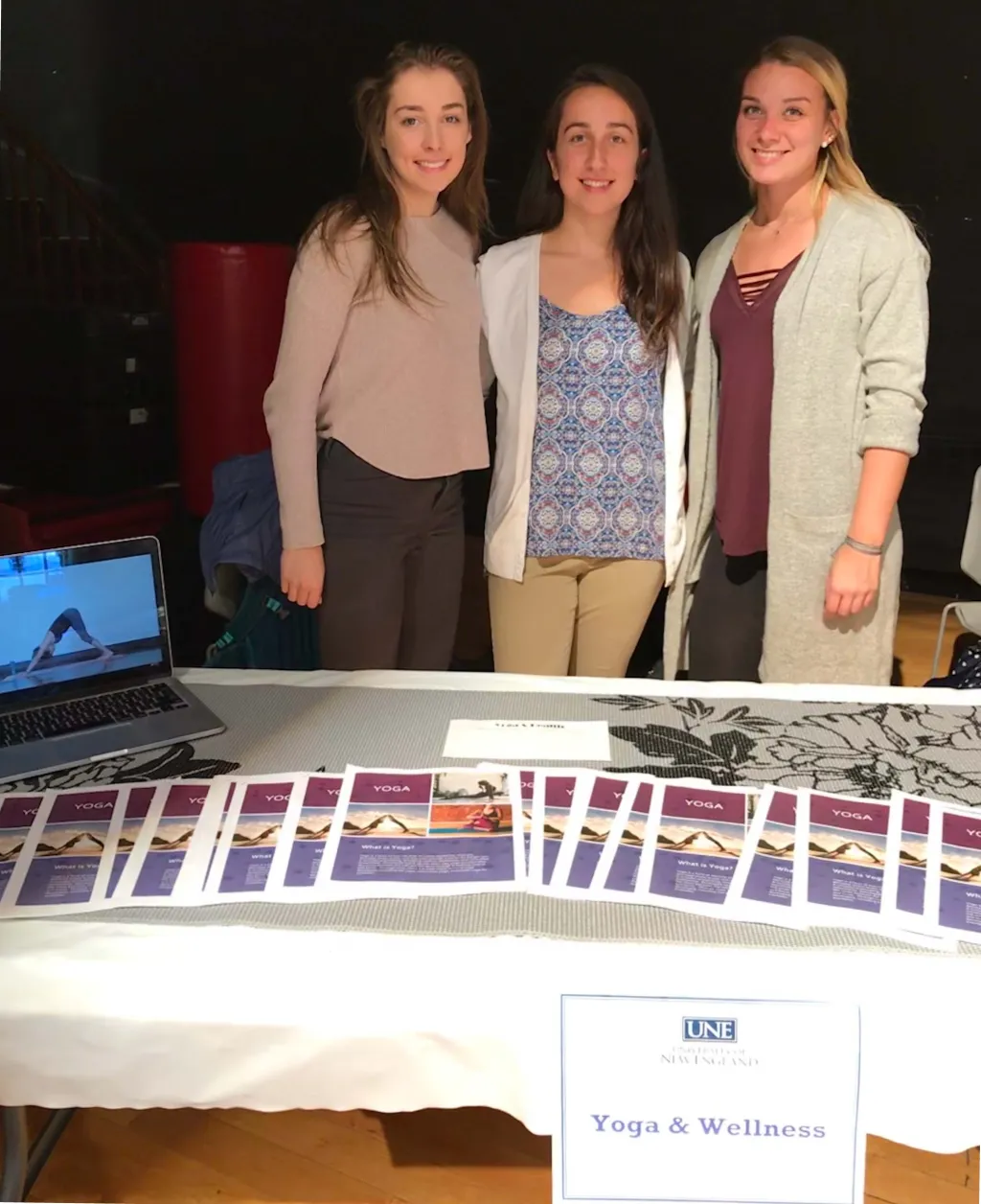 Lindsay Maffei, Corey Young and Morgan Kelley staff the yoga table.