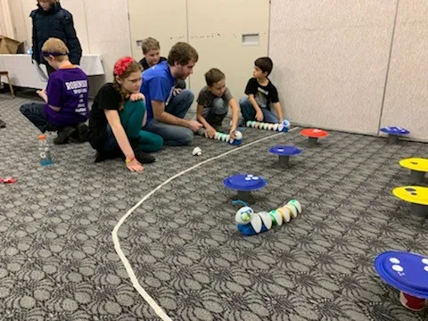 UNE student Shawn Pilling leads children through the obstacle course