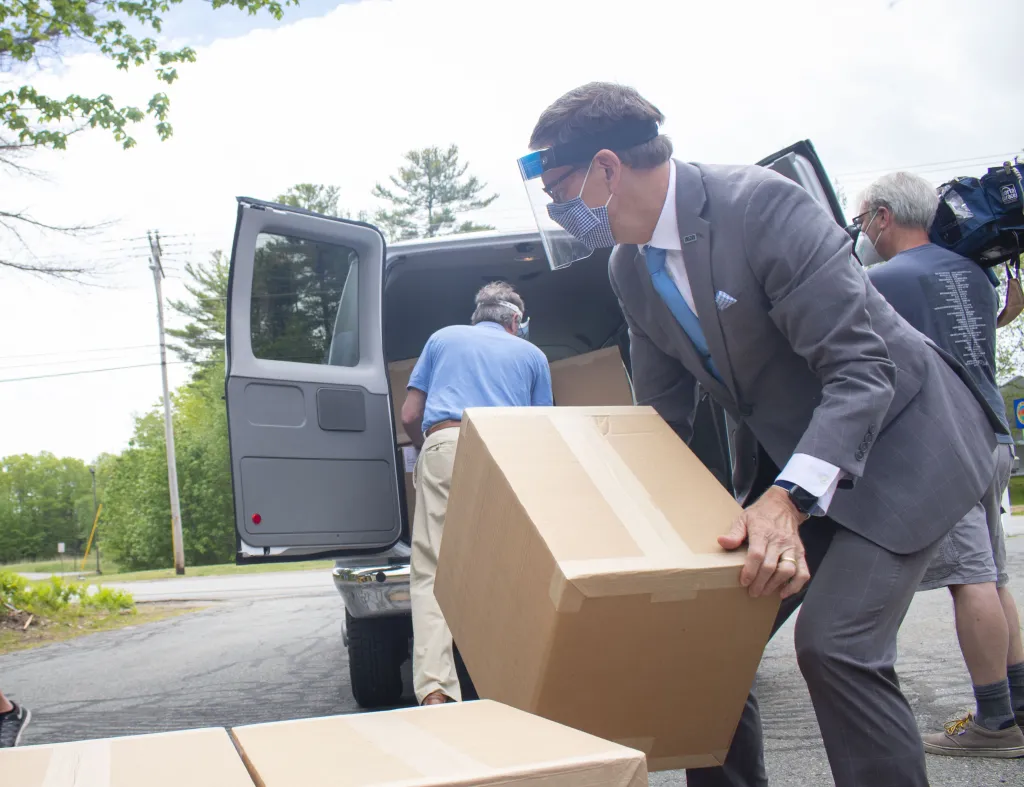 Herbert and Tyson load boxes of face shields into a van for transport to UNE.