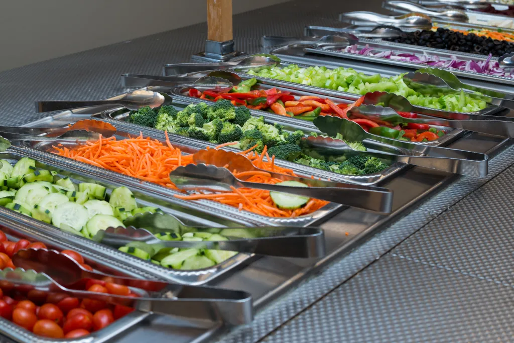 Peppers, cucumbers, carrots and other vegetables in the salad bar