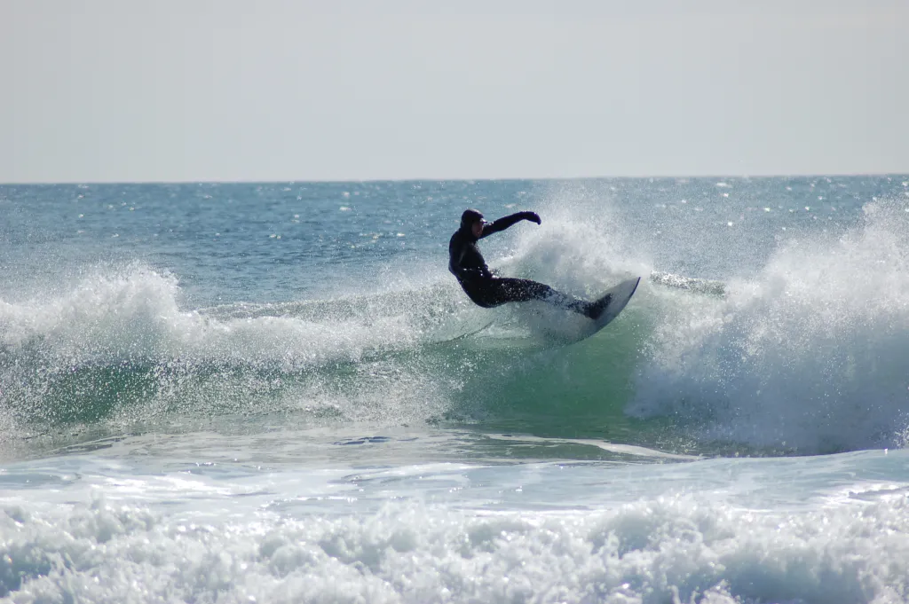 A member of the U N E surf club catches a wave