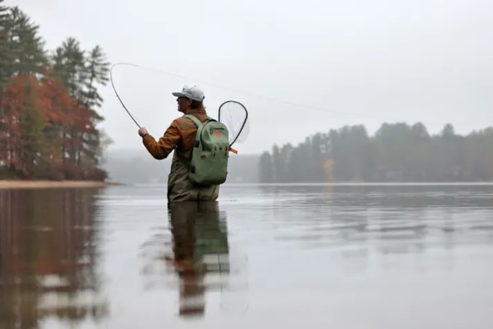 A U N E student casts a line while in a lake on a foggy autumn day