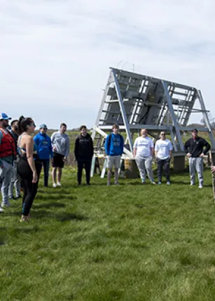 A student constructs a compass from wooden sticks