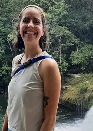 Celia Larson poses in front of a waterfall