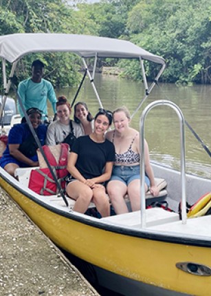 Celia Larson poses with her clinical group on a yellow boat
