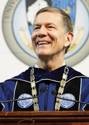 President Herbert speaks at a podium at U N E's 2022 commencement ceremony