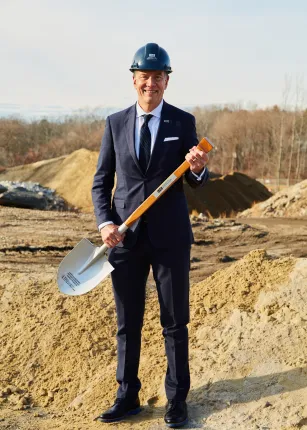 UNE President James Herbert poses with a shovel