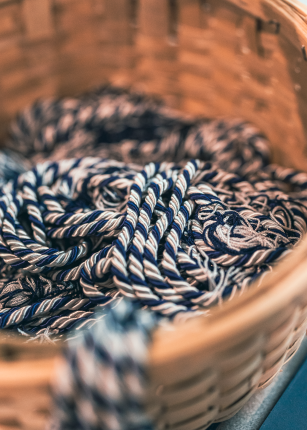 Blue and white graduation cords are shown in a basket