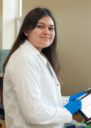 A student holds an iPad and poses in the Portland Laboratory for Biotechnology and Health Sciences