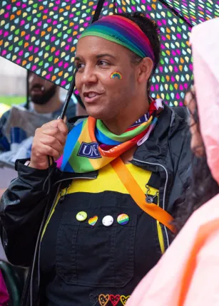 A U N E student wearing a rainbow headband and bandana at a Portland Pride Parade