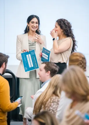Two students smile after learning their residency placements
