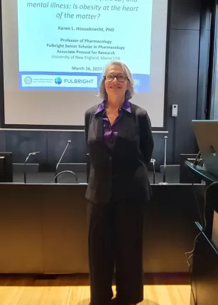 Karen Houseknech poses in front of a presentation