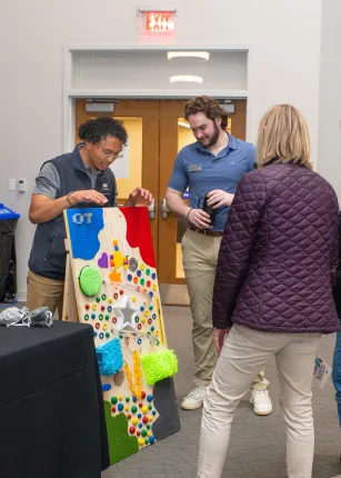 People observe a stand-up sensory board
