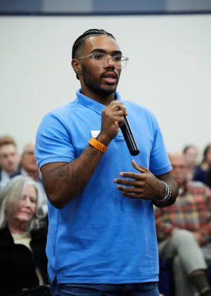 A student stands to ask a question