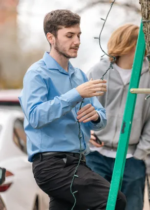 UNE students help to decorate Biddeford with lights.