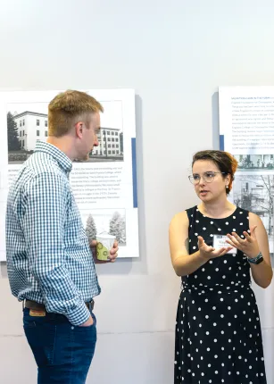 A UNE student explains research to Zach Olson, wildlife biologist, and James Herbert, UNE president at the Fall Reseach Symposium.