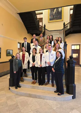 UNE and Tufts medical students pose for a photo on the grand staircase of the Maine State House