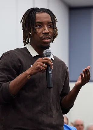 A student speaks into a microphone at an event