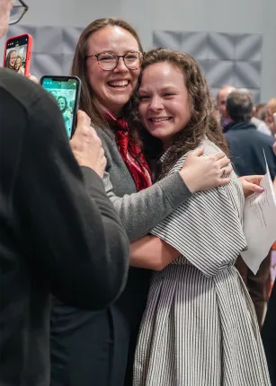 Two U N E College of Osteopathic Medicine students embrace and smile while celebrating Match Day.
