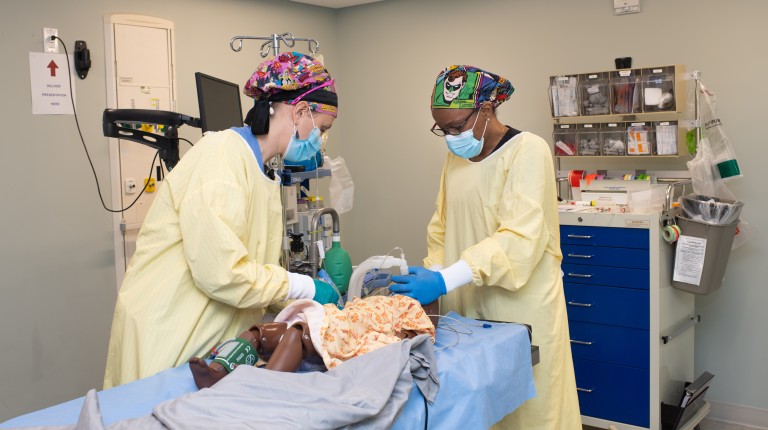 Two Nurse Anesthesia students practice on a simulator in UNE's clinical simulation center