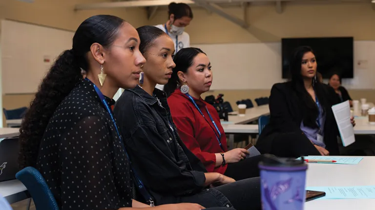 Three individuals listening during the UArctic Assembly