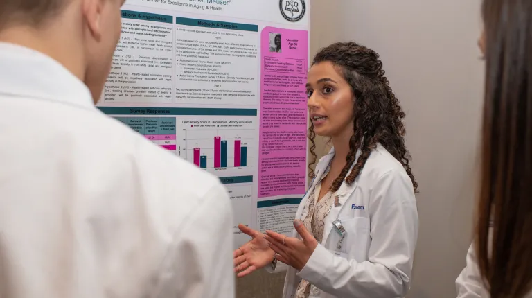 A student presents her research to a crowd