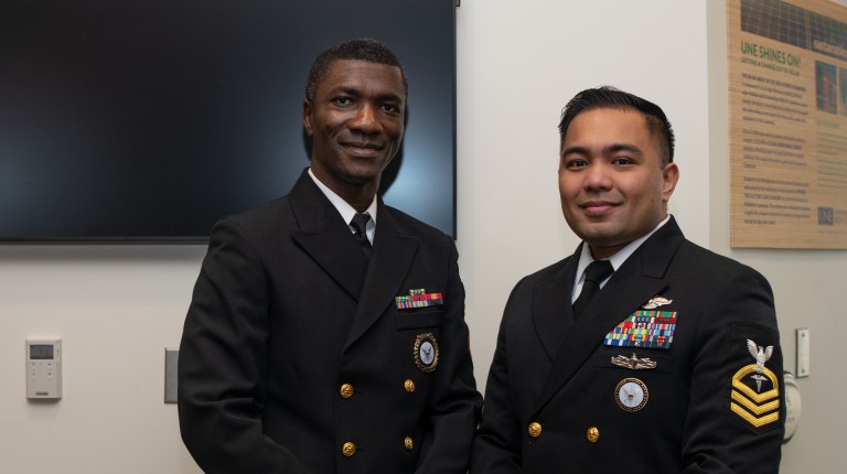 Two male students pose in military colors representing their military matches