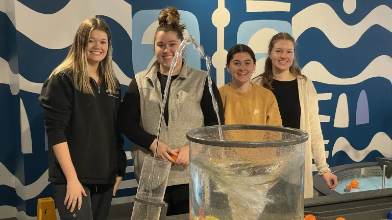 Students pose in front of water mechanisms