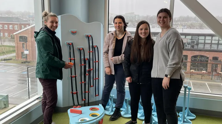 Students pose with kids' climbing equipment