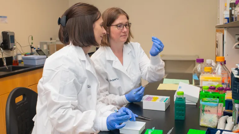 A student and professor review a slide