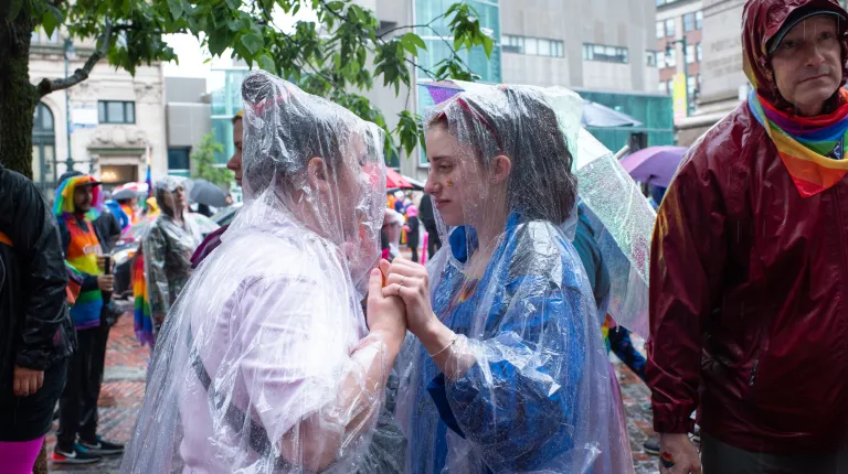 Two woman grasp hands at the parade