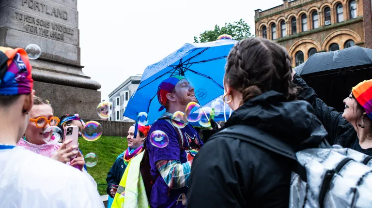 UNE community members gather in Monument Square surrounded by bubbles