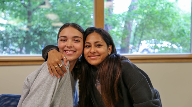 two students hugging and smiling 