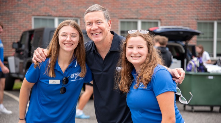UNE President James Herbert poses with two students