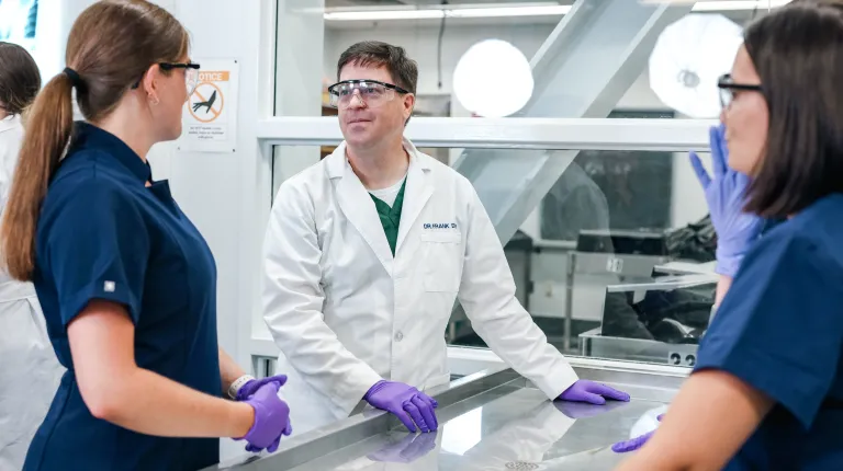 Professor Frank Daly talks with students in the human body donor lab